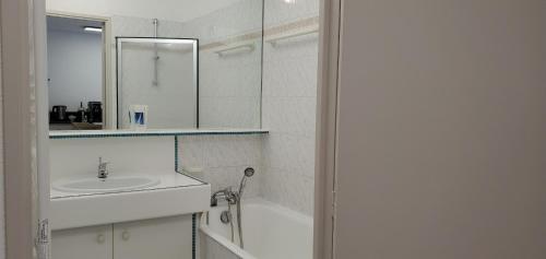 une salle de bain blanche avec un lavabo et un miroir dans l'établissement Port FREJUS OPEN 2 pieces 40m2, à Fréjus