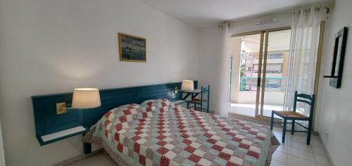 - une chambre avec un lit doté d'une couette rouge et blanche dans l'établissement Port FREJUS OPEN 2 pieces 40m2, à Fréjus