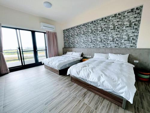 Shan-shui-liにあるNice Sleep Homestayのレンガの壁、ベッド2台が備わるベッドルーム1室が備わります。