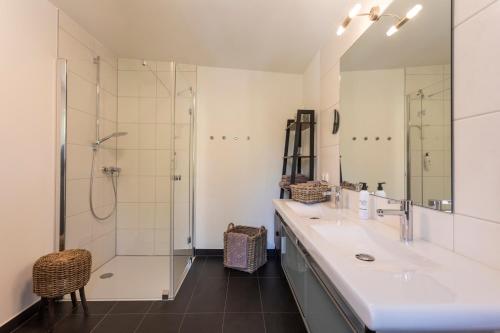 a bathroom with two sinks and a shower at Seeapartment Da Leopoldo II in Velden am Wörthersee