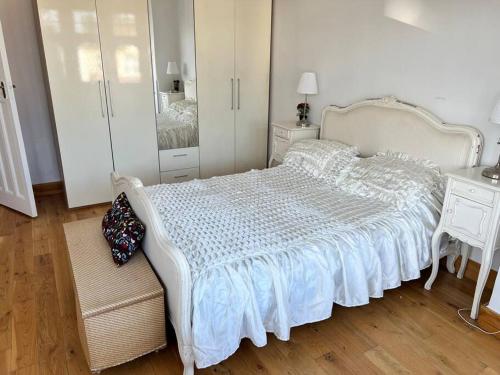 a bedroom with a white bed and a mirror at Large whole house with 7 bedrooms in S.Norwood in Norwood