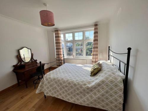 a bedroom with a bed and a mirror and a window at Large whole house with 7 bedrooms in S.Norwood in Norwood