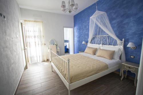 ランペドゥーザにあるヴェヌスタスのベッドルーム1室(青い壁の白いベッド1台付)