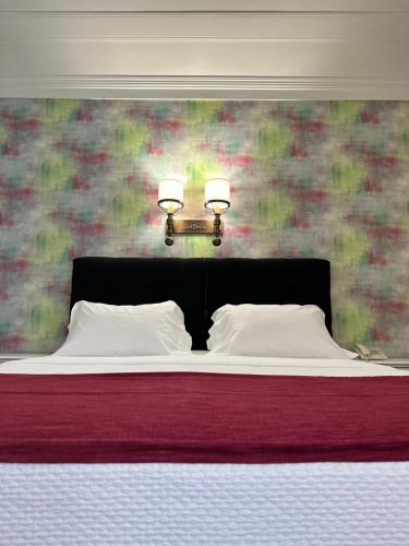 a bedroom with a bed with two lights on it at Hotel Joao Padeiro in Aveiro