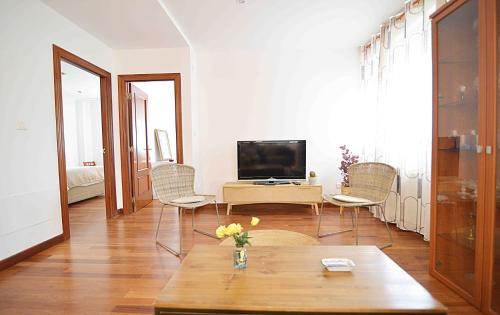 een woonkamer met een televisie en een tafel bij Precioso apartamento en Santander in Santander
