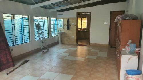 a room with a tile floor and a hallway with windows at A village home away from City in Ullāpāra
