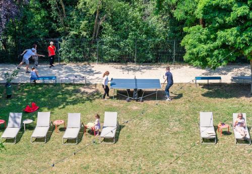 a group of people playing ping pong in a park at B&B HOTEL Lyon Nord 4 étoiles in Dardilly