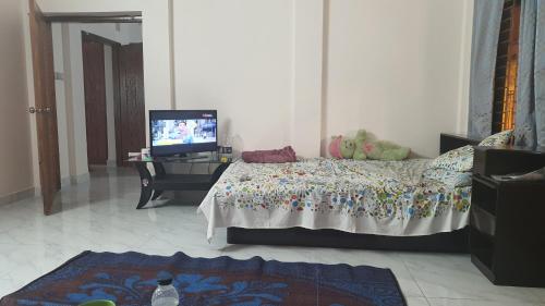 a bedroom with a bed and a tv in it at A village home away from City in Ullāpāra