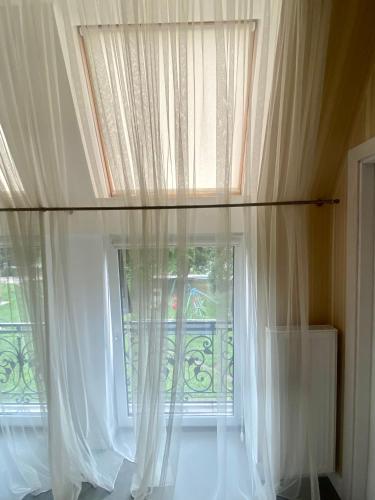 a large window with white curtains in a room at Boutique Hotel Deluxe in Kamianets-Podilskyi