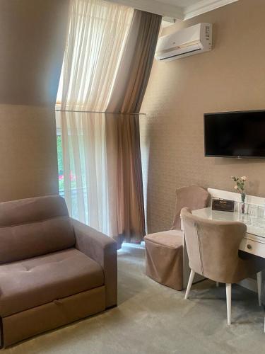 a living room with a couch and a chair and a table at Boutique Hotel Deluxe in Kamianets-Podilskyi