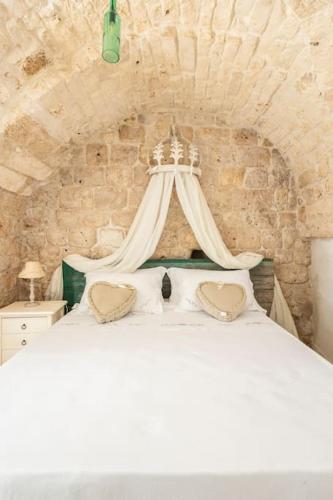 - une chambre avec un lit blanc à baldaquin dans l'établissement Dimora Stella, à Carovigno