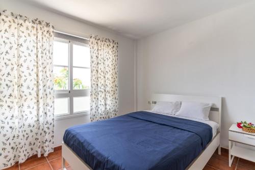 a bedroom with a blue bed and a window at Oceanfront Rainbow Costa Adeje 14V35 in Callao Salvaje