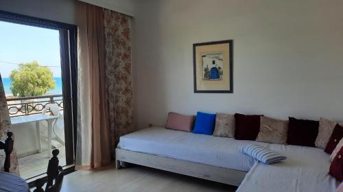 a living room with a couch and a large window at Chris Studios & Apartments in Lechaio