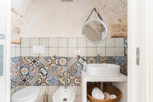 La salle de bains est pourvue de toilettes, d'un lavabo et d'un miroir. dans l'établissement Dimora Stella, à Carovigno