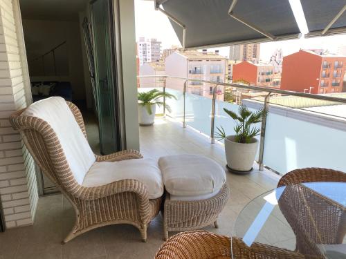 balcón con sillas de mimbre y mesa en el balcón en Apartment Ramon, en Sant Antoni de Calonge