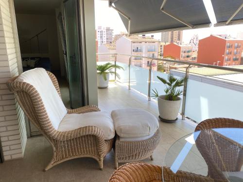 a balcony with wicker chairs and a table on a balcony at Apartment Ramon in Sant Antoni de Calonge