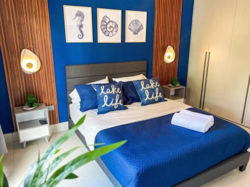 um quarto azul com uma cama com lençóis e almofadas azuis em Thematic beach apartment in CapCana area em Punta Cana