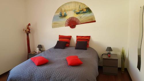 a bedroom with a bed with two red pillows at Domaine des Rigaud in Garchizy
