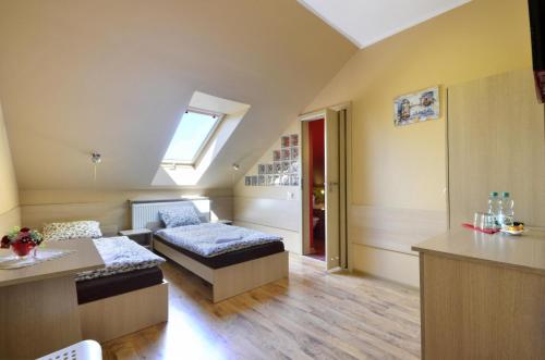 a room with a bed and a couch and a window at Pensjonat Paskal in Czerlejno