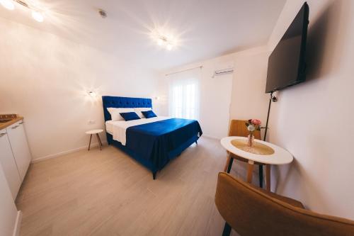 1 dormitorio con 1 cama azul y TV en Elegant Studio Apartments Lasta en Mostar