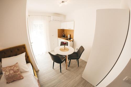 a small room with a bed and a table and chairs at Elegant Studio Apartments Lasta in Mostar