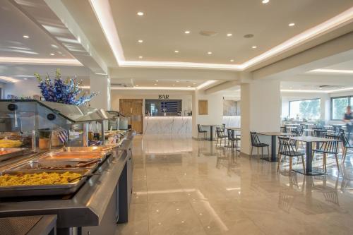 a buffet line in a restaurant with tables and chairs at Lardos Bay Hotel in Lardos