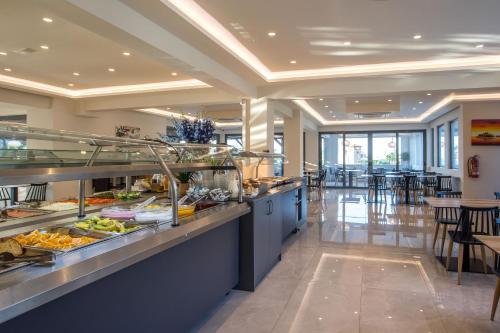 a buffet line in a restaurant with tables and chairs at Lardos Bay Hotel in Lardos