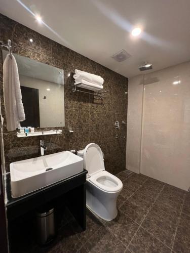 een badkamer met een toilet, een wastafel en een spiegel bij Hotel Black Diamond - Inside Airport in Kathmandu