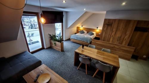 a bedroom with a bed and a table and chairs at Willa Kania in Szczawnica