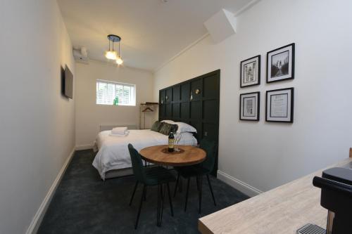 um quarto com uma cama, uma mesa e cadeiras em The Hop Merchant's House em Worcester