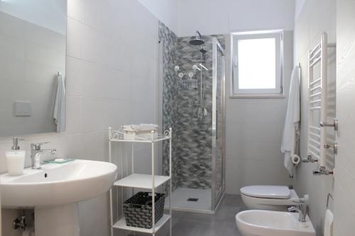 y baño blanco con lavabo y ducha. en Casa CEREUS, en Modugno