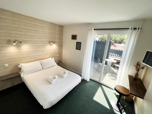 a hotel room with a bed and a balcony at Diu Biban in Hossegor
