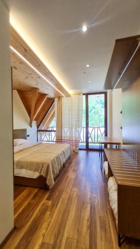 a bedroom with a bed and a wooden floor at NeoKulla Hotel - Hikers Hive in Valbonë
