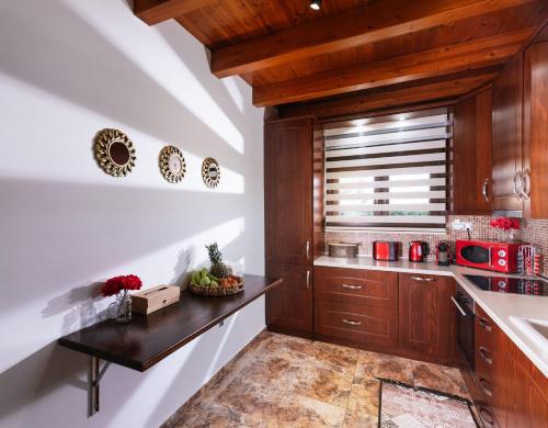 - une cuisine avec des placards en bois et un comptoir dans l'établissement SandShine Luxury Villa, à Kalamaki
