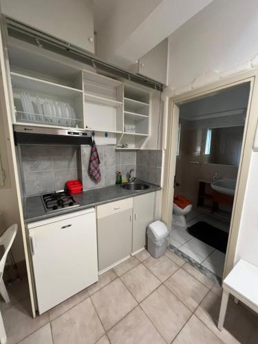 a small kitchen with white cabinets and a sink at Villa Katia in Asprovalta