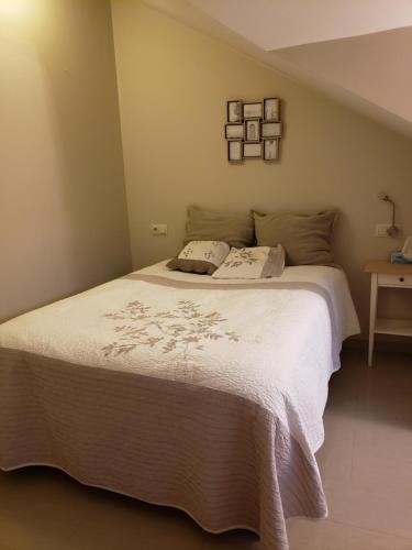 a bedroom with a large bed with white sheets at ÁTICO SANXENXO CON TERRAZAS Y VISTAS AL MAR in Sanxenxo