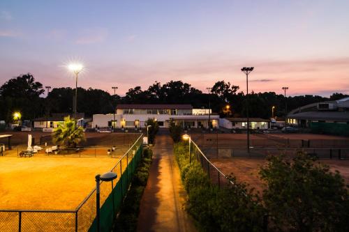a tennis court at night with lights on at Le Dune Sicily Hotel in Catania