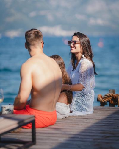 a group of people sitting on a dock at Kondo Hotel Allure in Budva