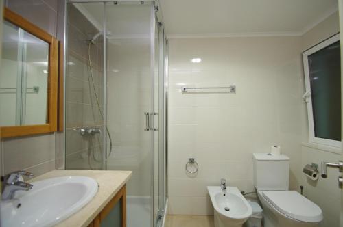 y baño con ducha, aseo y lavamanos. en Apartamentos Vila Nova, en Vila Nova de Milfontes