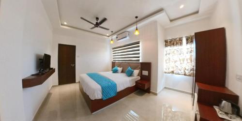 um quarto com uma cama e uma televisão num quarto em Heaven Stay em Port Blair