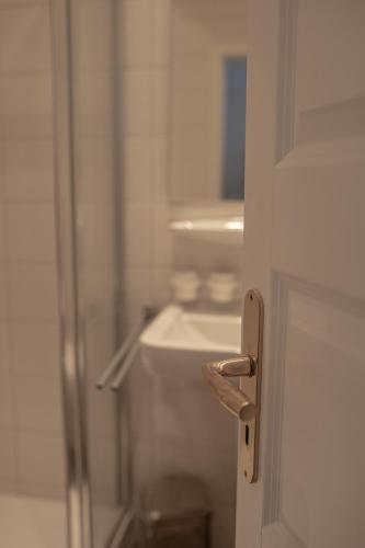 a door to a bathroom with a sink and a mirror at Hotel Seehof Norderney OHG in Norderney