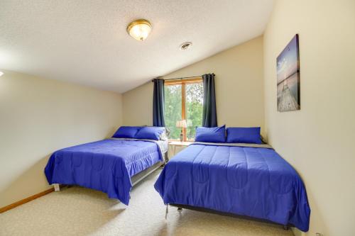 two beds in a room with blue sheets at Richville Vacation Rental with Fire Pit Near Trails in Ottertail