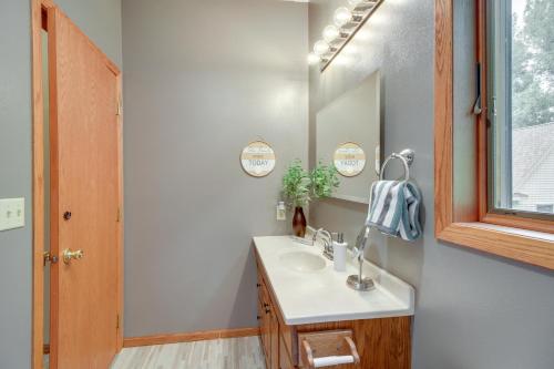 a bathroom with a sink and a mirror at Richville Vacation Rental with Fire Pit Near Trails in Ottertail