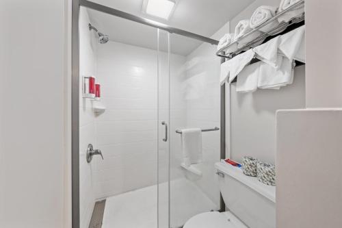 a white bathroom with a shower and a toilet at SureStay Hotel by Best Western Virginia Beach Royal Clipper in Virginia Beach