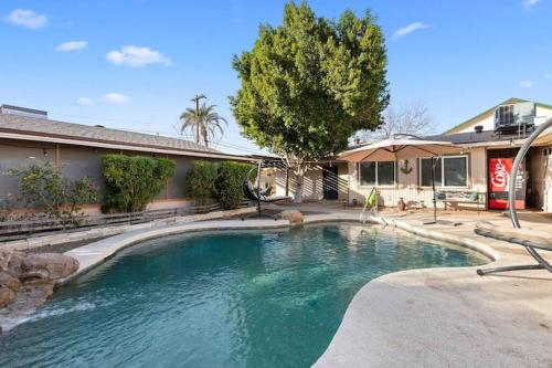 a swimming pool in front of a house at Loma Linda Courtyard Suites in Phoenix