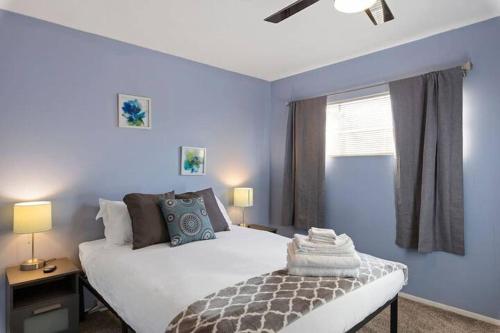 a bedroom with a white bed and a blue wall at Loma Linda Courtyard Suites in Phoenix