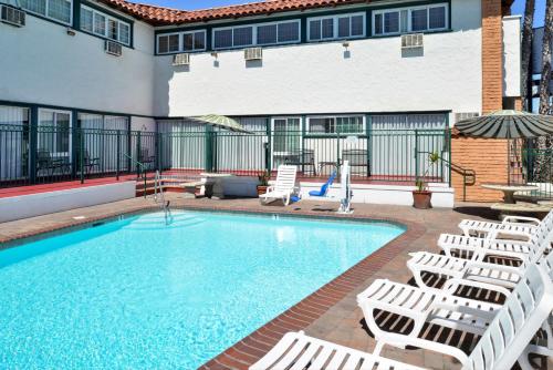 a pool with chaise lounge chairs and a hotel at Americas Best Value Inn Loma Lodge in San Diego