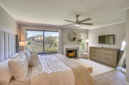 um quarto com uma cama grande e uma lareira em Laguna Niguel Townhouse with Community Pool Access! em Laguna Niguel