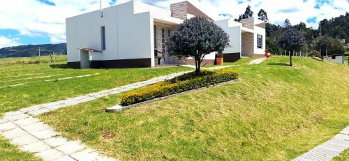 a house on a hill with a tree in the yard at Apartamento - ApartaSuite ARGUS in Paipa