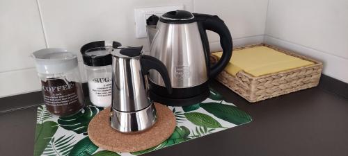 INTERNO NOVE - appartamento a Corsico في كورسيكو: آلة صنع القهوة على منضدة بجوار سلة